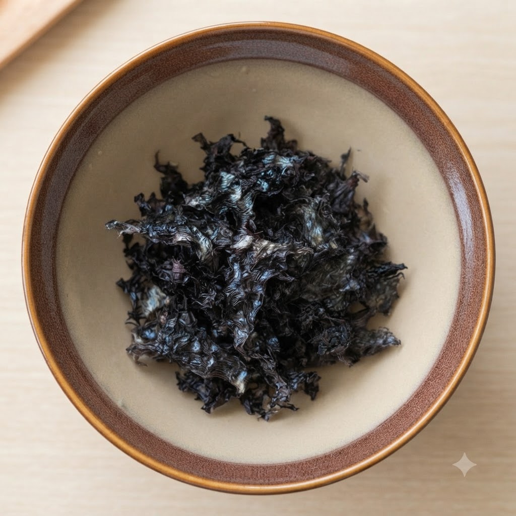 Dried seaweed flakes and white sesame seeds resting inside a brown ceramic bowl.