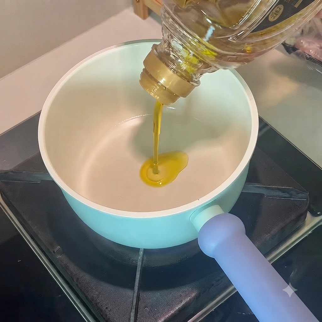 Cooking oil being poured into a light blue pot containing star anise and bay leaves.