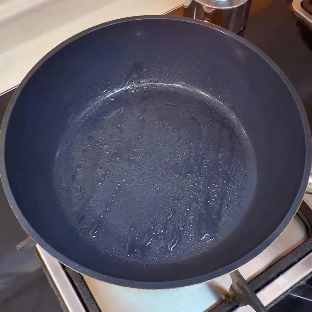 An empty heated pan getting ready for cooking or showing the initial stage of oil heating.