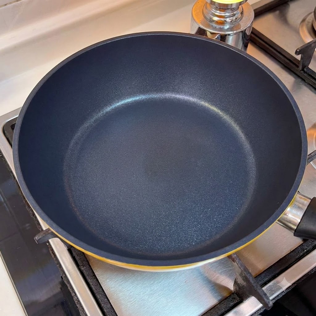 An empty frying pan on the stove burner.