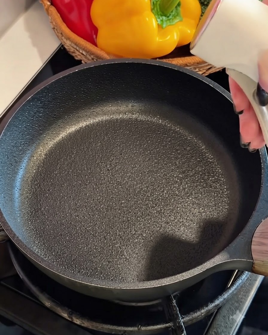 Crab stick egg mixture being poured into a greased hot frying pan.