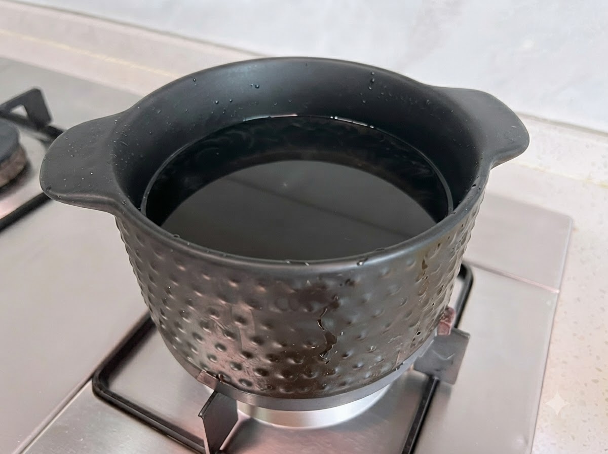 Two spoons of soybean paste being dissolved in a pot of boiling water.