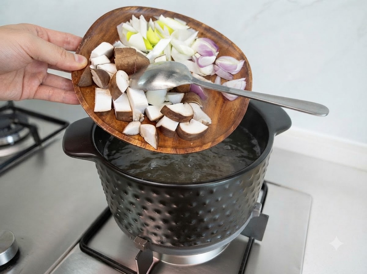 Diced shiitake mushrooms, onions, and scallions being poured from a wooden plate into the boiling soup.