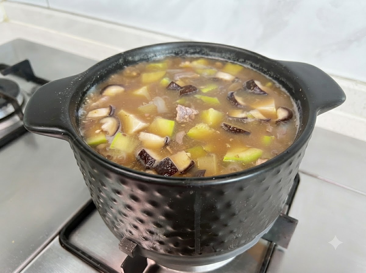 Beef powder and salt being added to season the bubbling Doenjang Jigae stew.