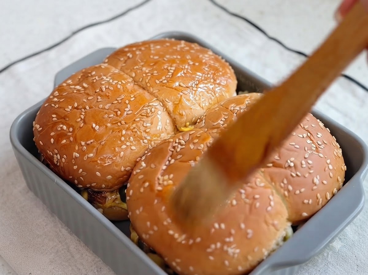 Freshly chopped green coriander leaves being scattered over the top of the glazed burger buns.